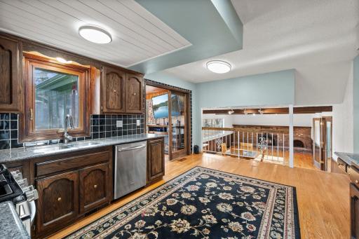 Spacious eat-in kitchen featuring rich wood cabinetry, stainless steel appliances, generous storage, granite counter-tops & hardwood floors. The open layout flows beautifully into the 4-season sun room & family room!!!