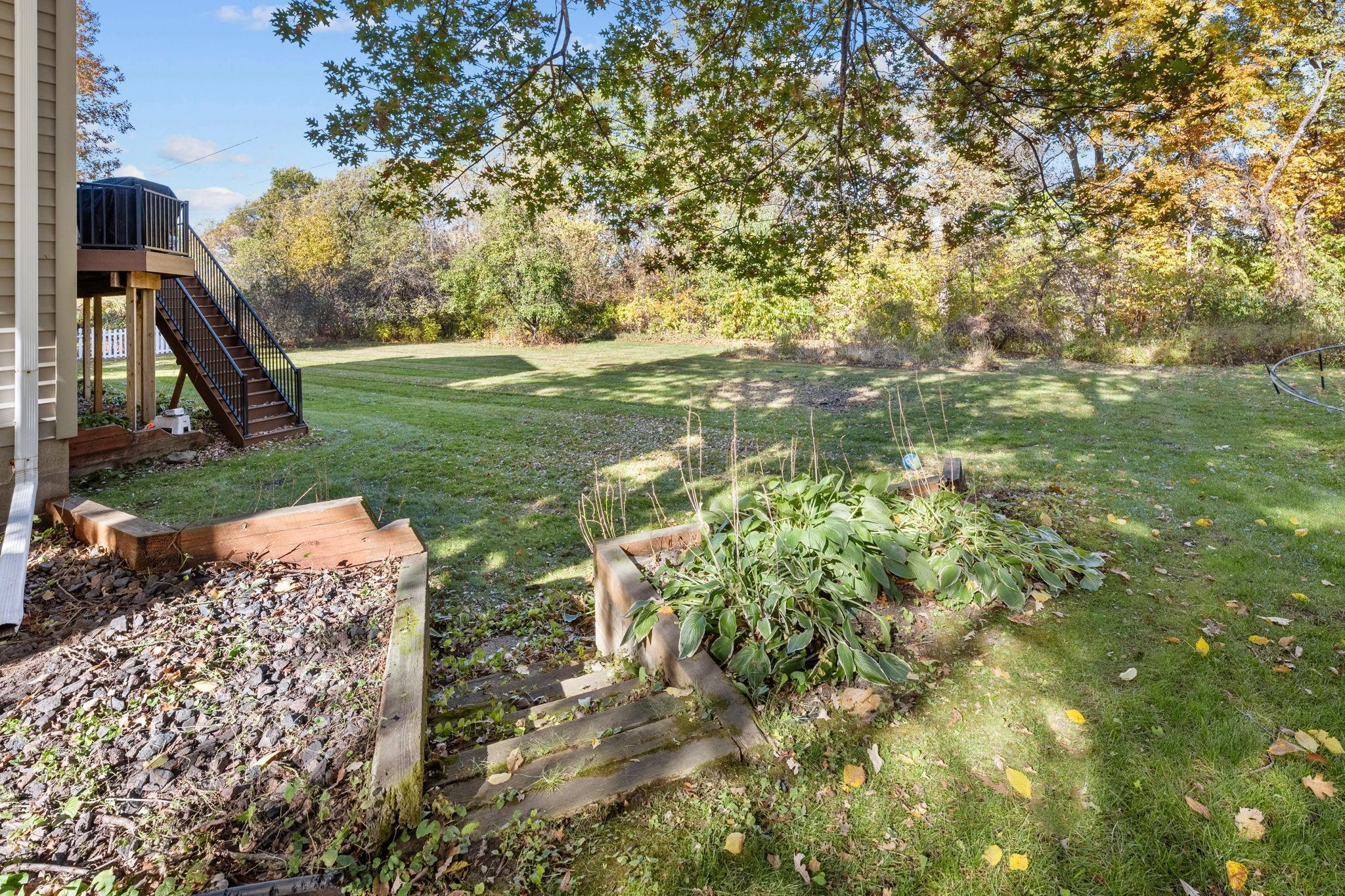 Expansive, flat back yard has the best of both worlds with private tree line, as well as the Crow River just below!