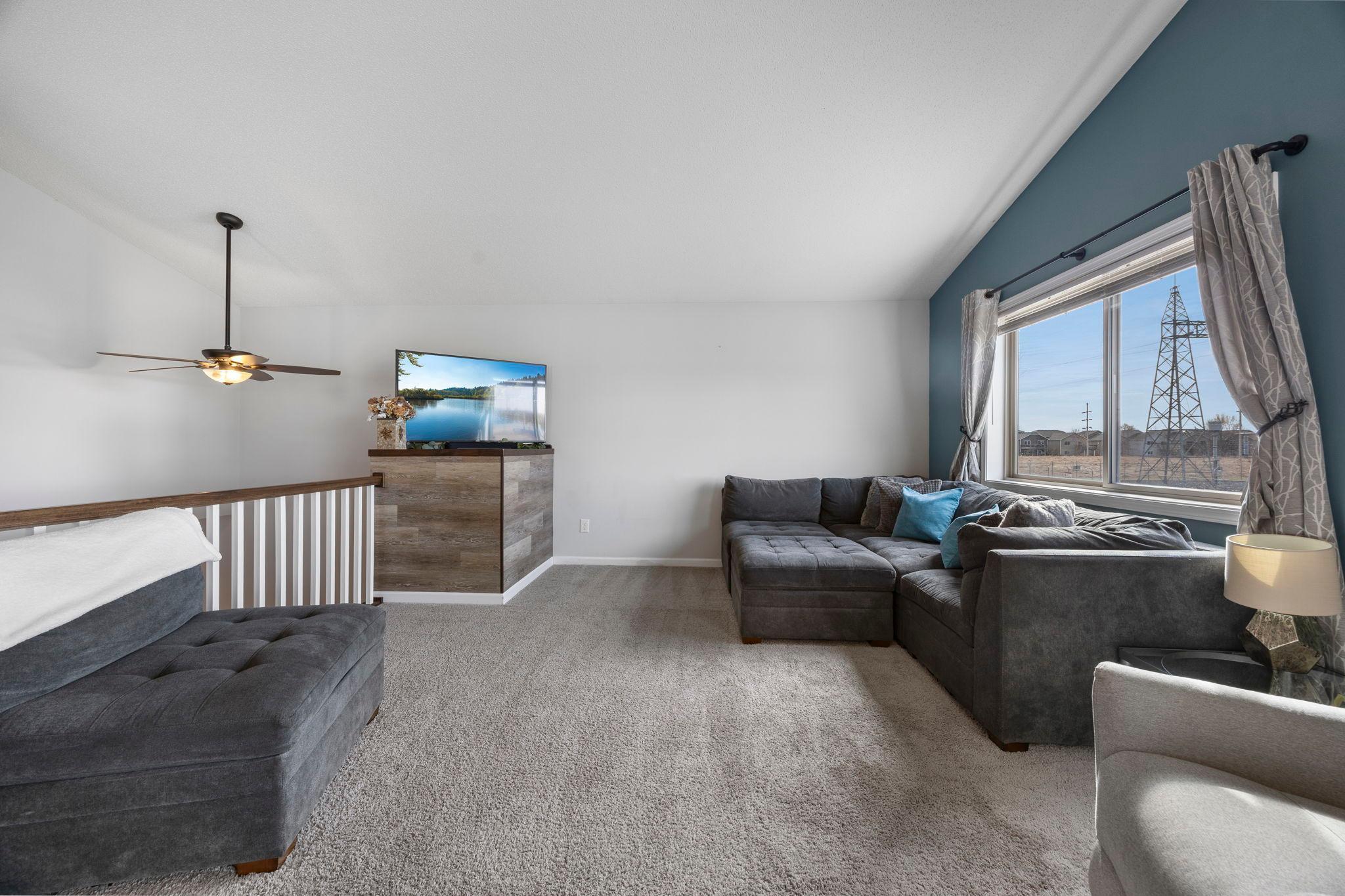 Living room features vaulted ceilings and a large window