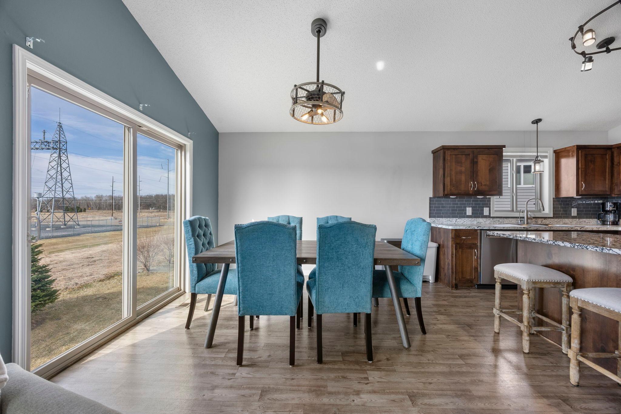 The dining area features a large window that fills the space with natural light, along with a beautiful chandelier that adds an elegant touch
