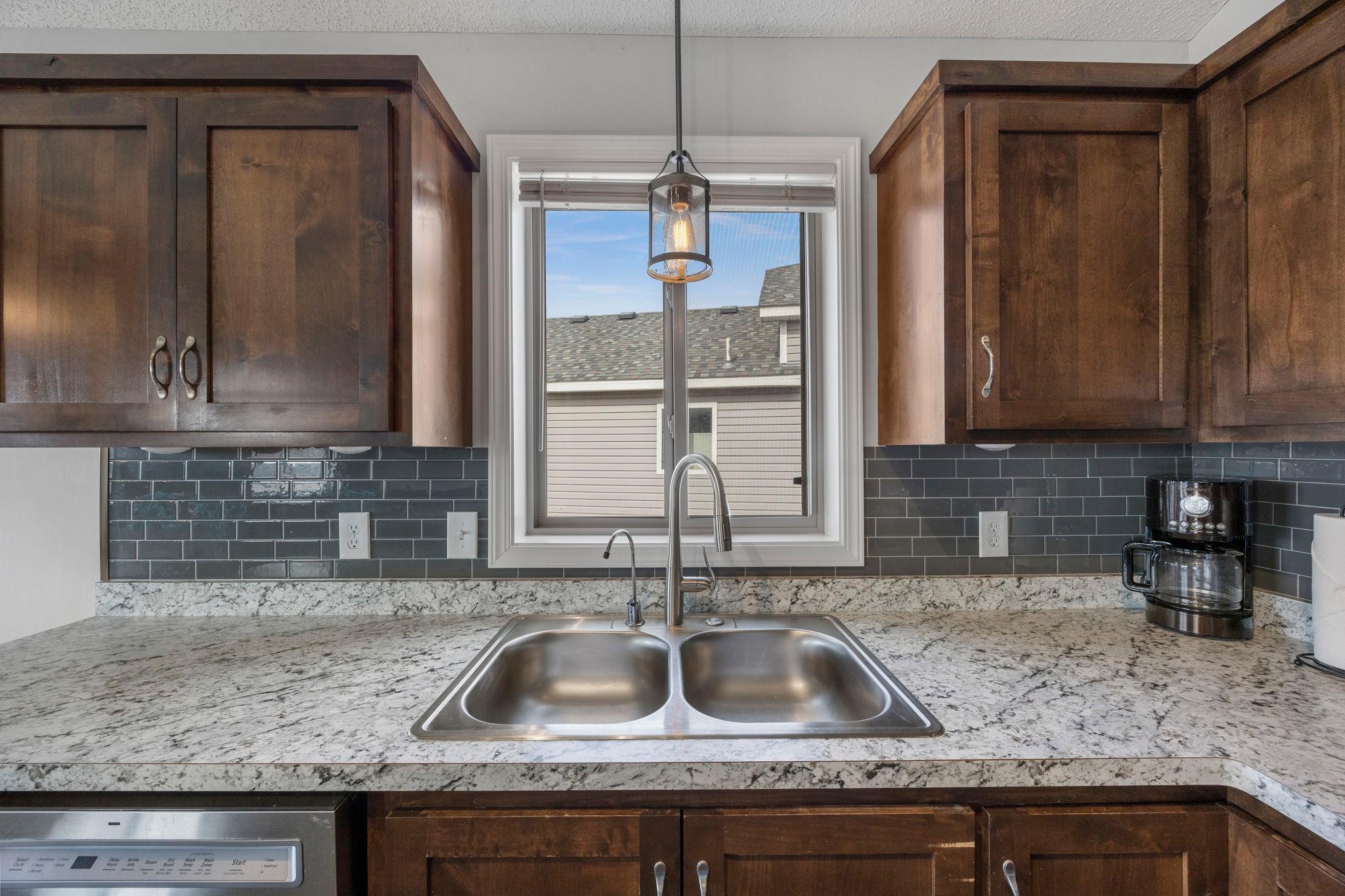 The kitchen sink area is accented by a lovely window, providing extra light into the space
