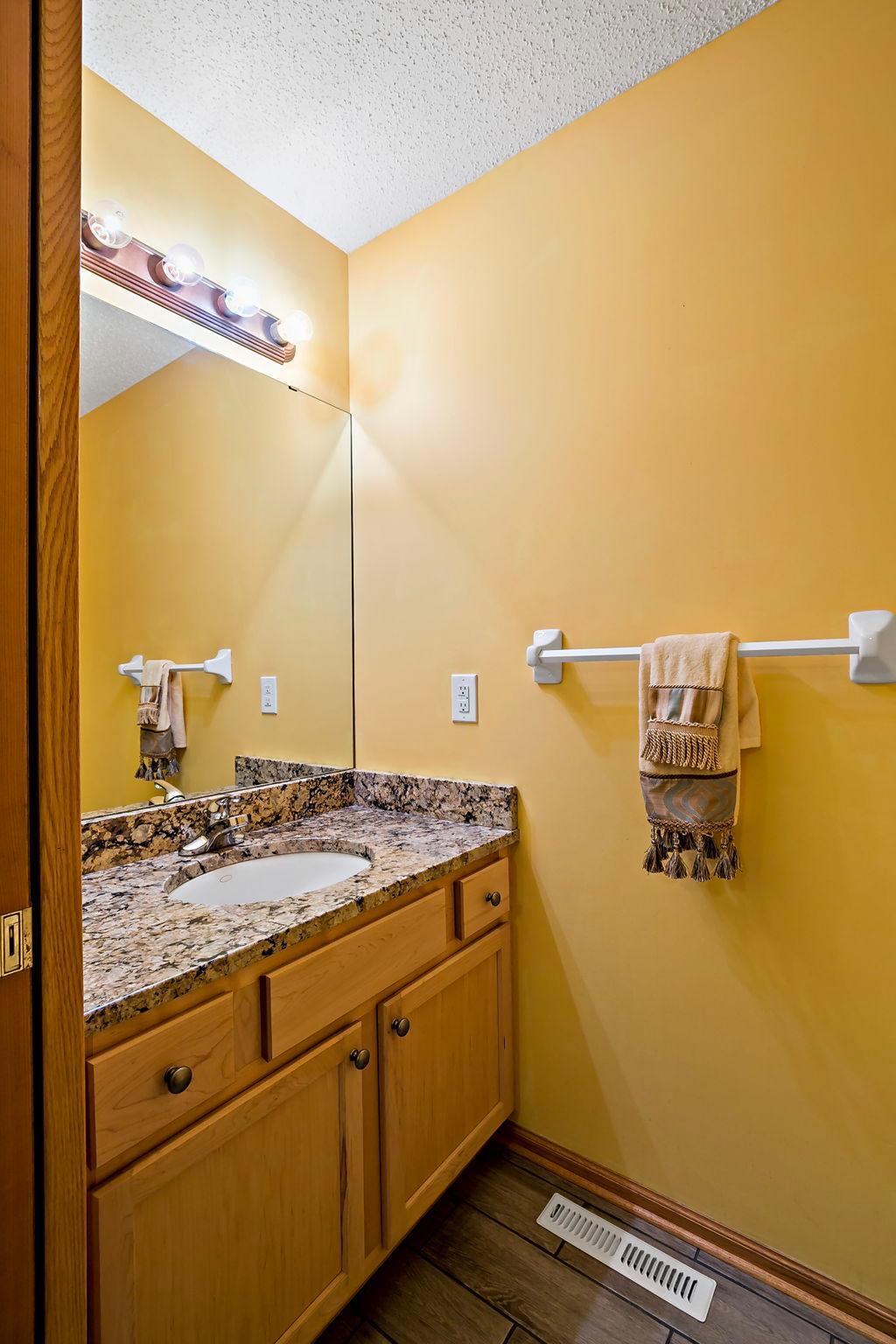 Cutest half bath featuring granite countertops and a space-saving pocket door.