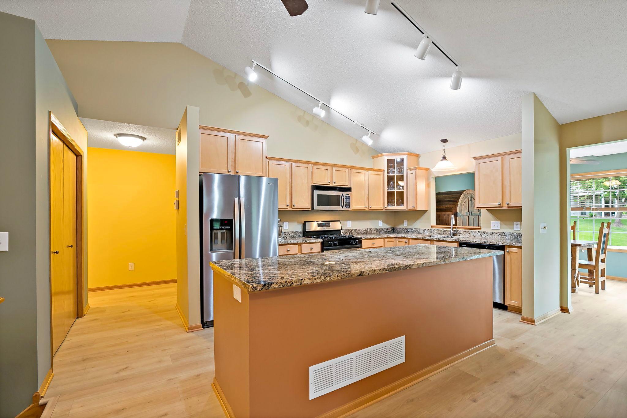 Updated kitchen with stainless appliances, granite counters, luxury flooring that flows through the kitchen, livingroom, dinning area, sunroom and all the hallways