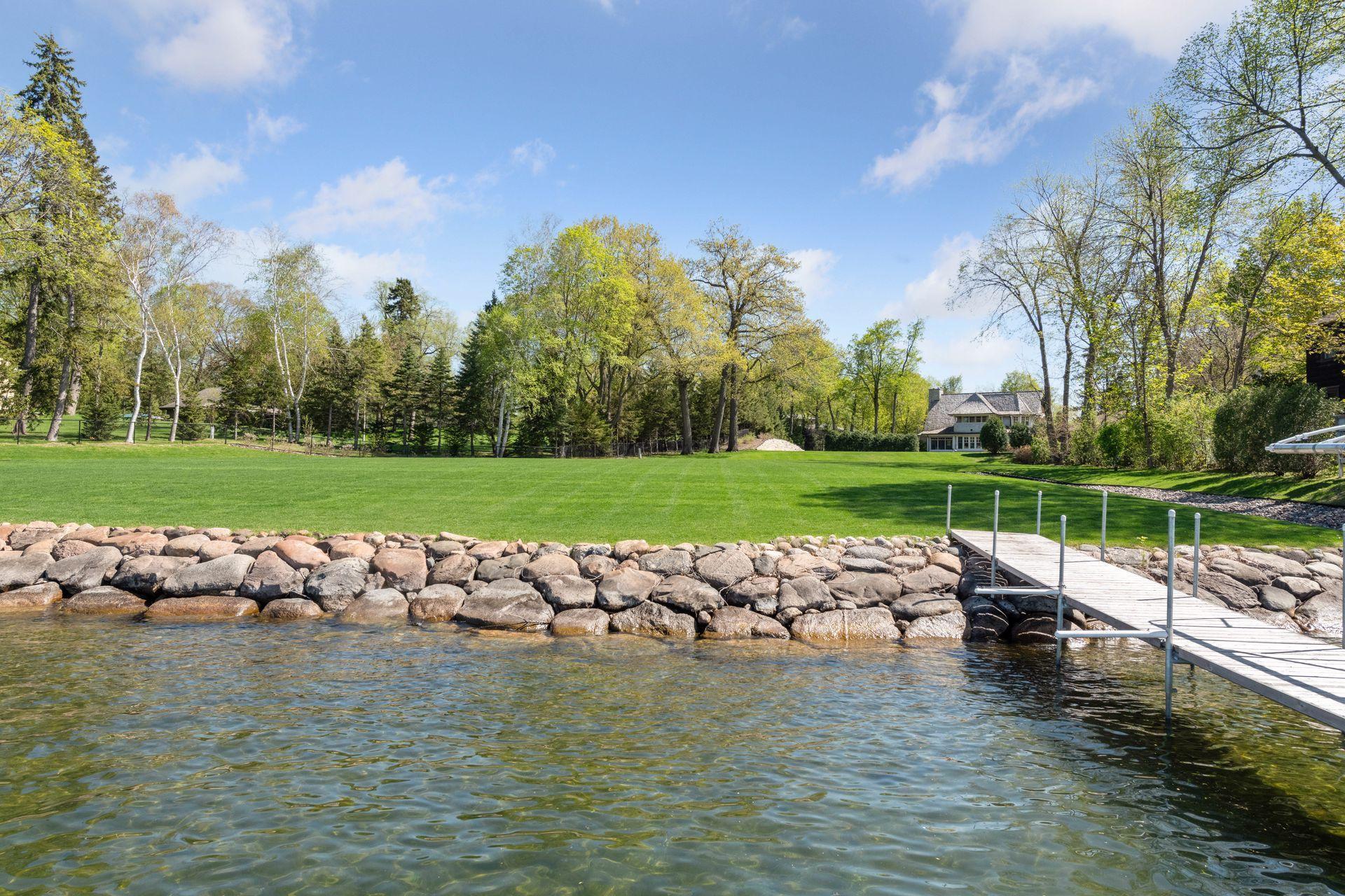 The large, level lot meets the water with a rip rapped shoreline.