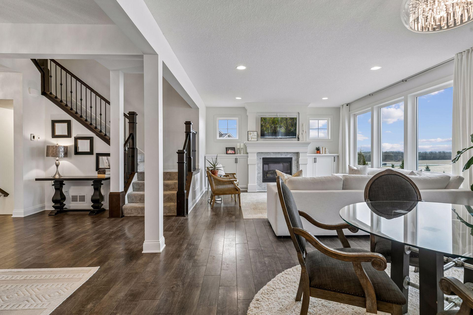The living room centers around a cozy fireplace, with a perfectly placed stairwell tying it all together.