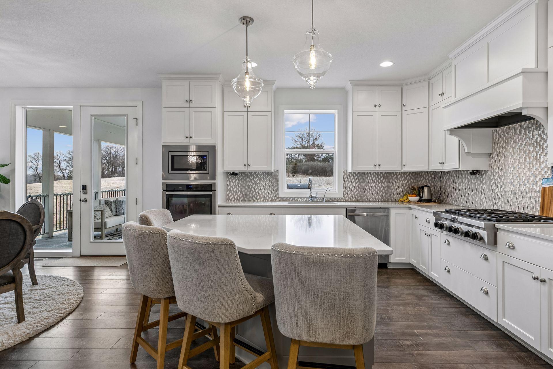 A large center island, modern lighting, and cabinetry that reaches the ceiling—both functional and beautiful.