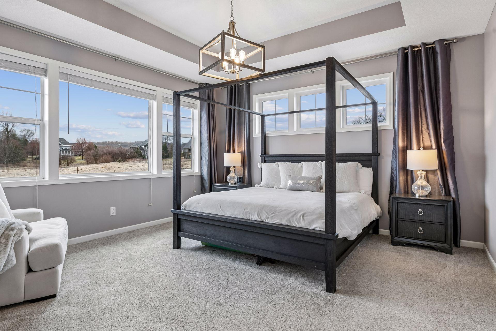 A light-filled primary suite with tray ceilings and windows that draw your eye outside.