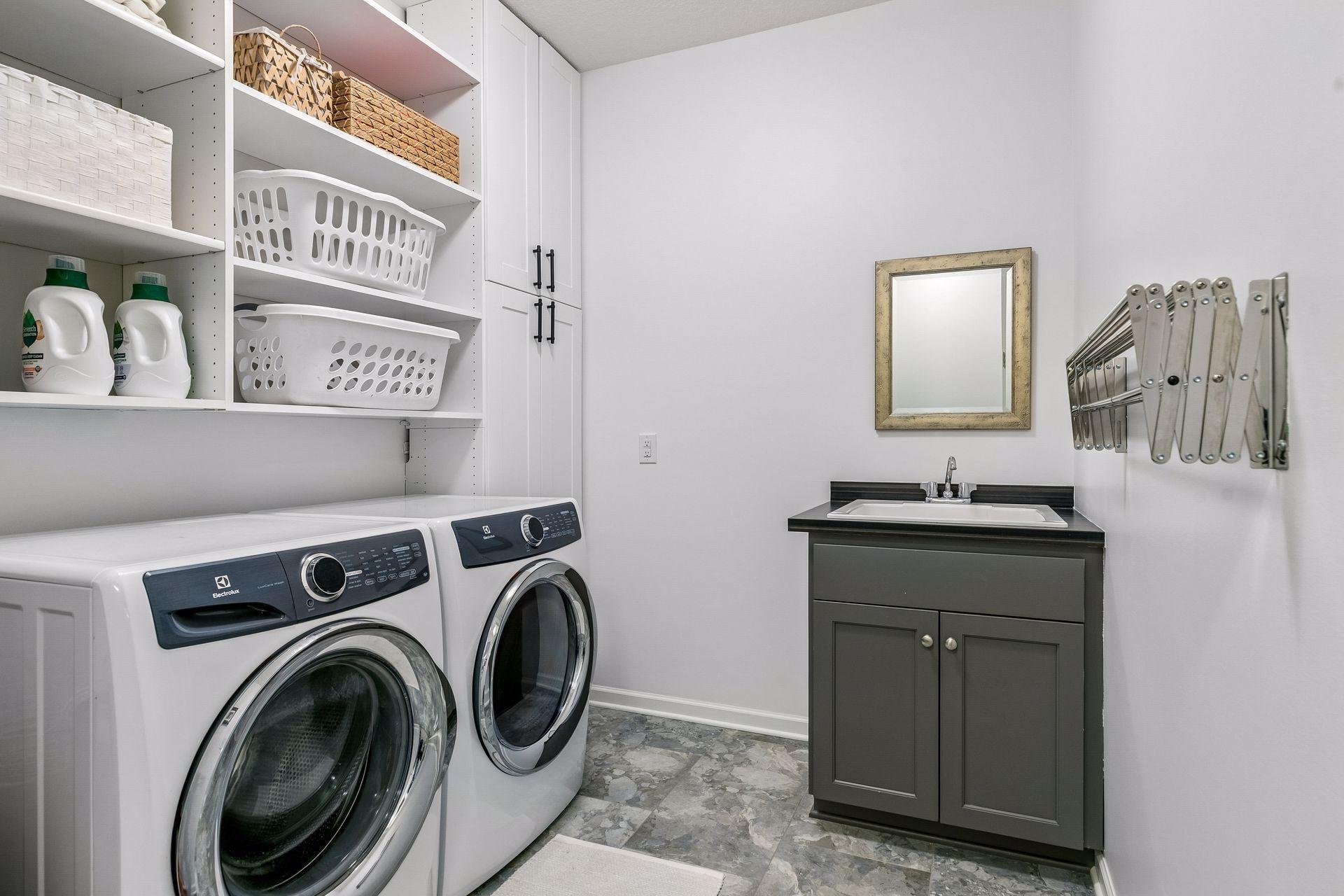 A dedicated laundry room with a door, ample storage, and a utility sink for everyday ease.