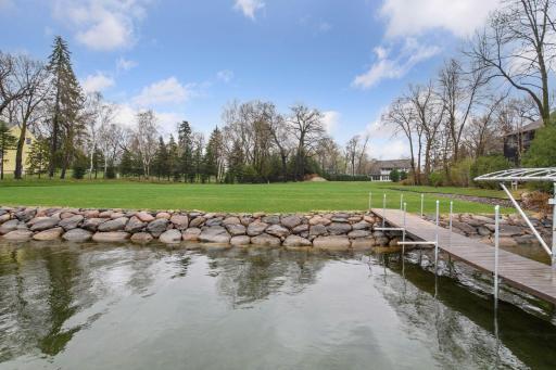 The large, level lot meets the water with a rip rapped shoreline.