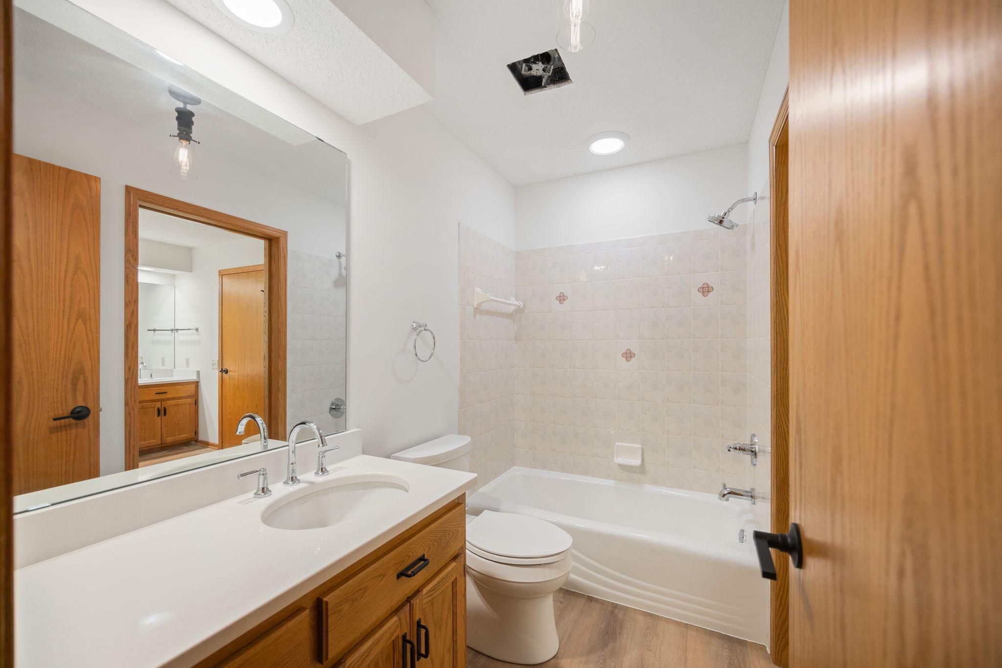 Main Level Bathroom with bath/shower combo- walks through to primary bath with shower