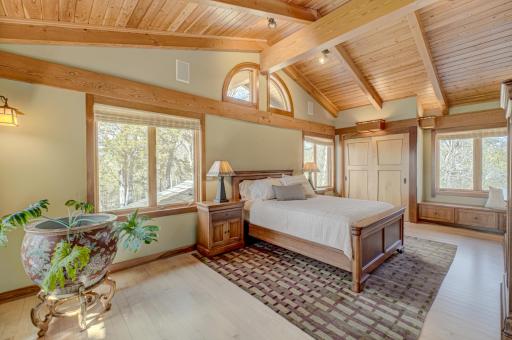 The secondary suite bedroom has vaulted ceilings and windows in three directions.