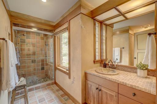 The lower level bath is tiled with reclaimed stone imported from France. The shower floor is made from Lake Superior rocks.