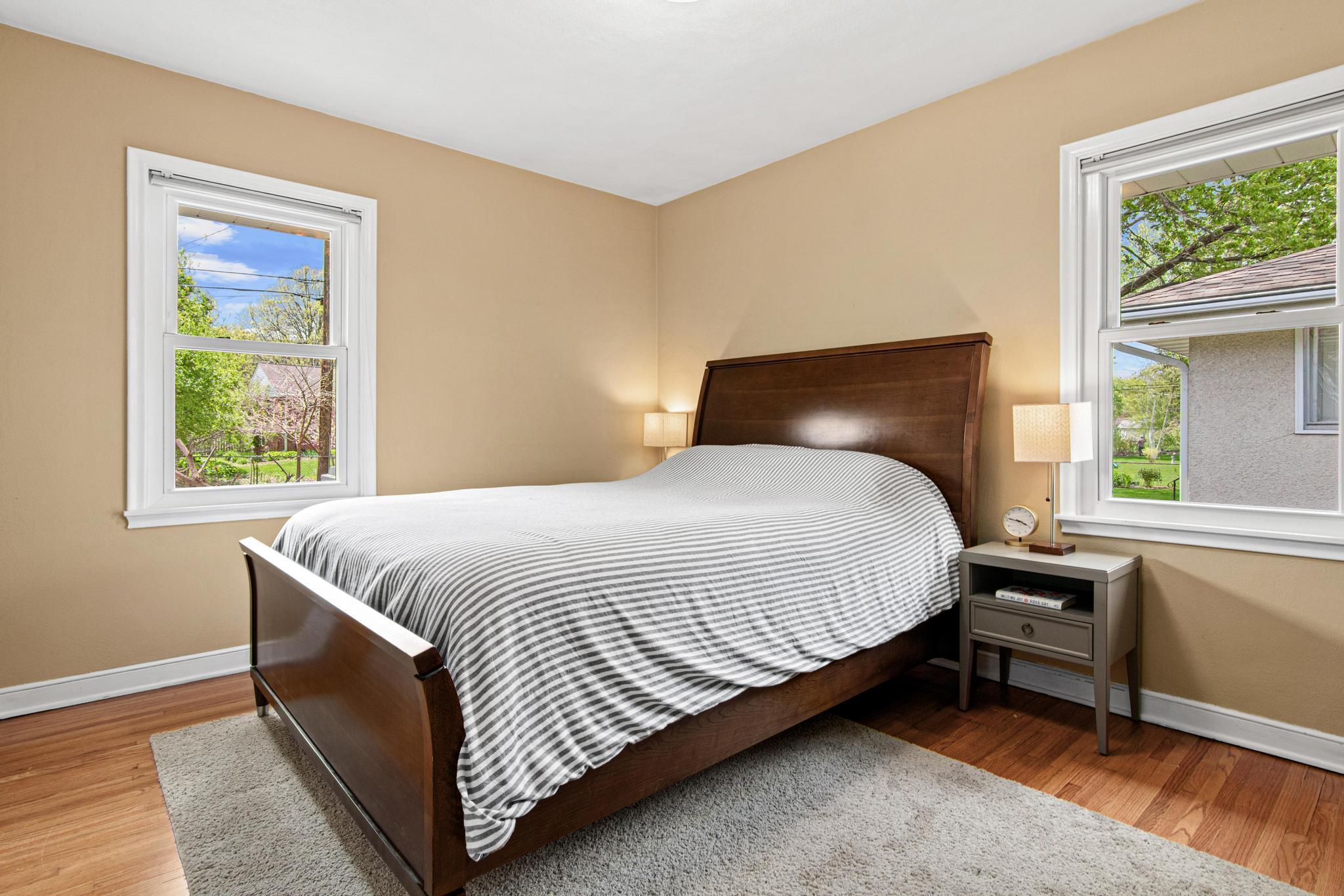 The primary bedroom is 1 of 3 on the main floor. Hardwood floors and new triple pane windows along with crisp white trim and a neutral wall color create a solid foundation for you to bring your decorative visions to life.