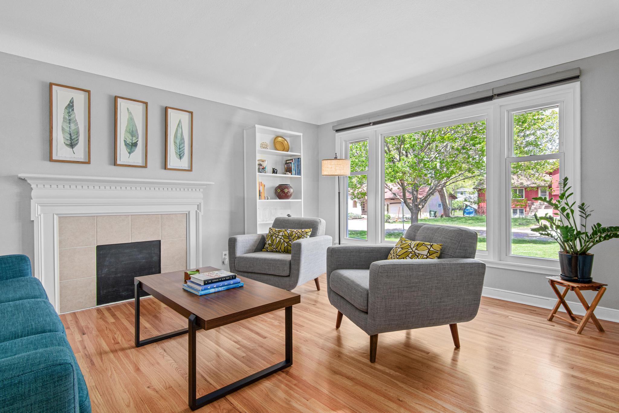 Through the front door you will find the spacious living room with newly refinished original hardwood floors, coved ceiling detail and lots of natural light thanks to the oversized triple pane windows that were installed in 2023.