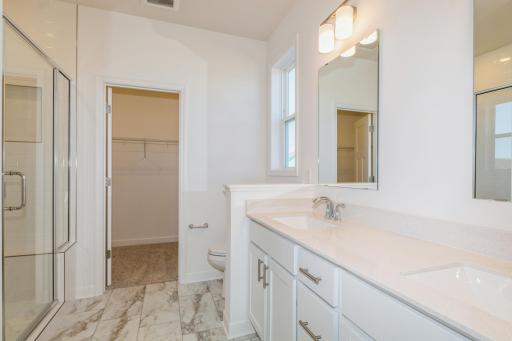 (Photo of similar home, features will vary) The en-suite bathroom features a walk-in shower with glass enclosure and convenient shelving to store bathing essentials
