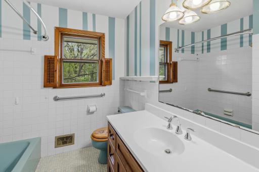 The main floor bathroom is a mix of retro and new. The vintage tub and toilet are complimented by a newer vanity and sink top.