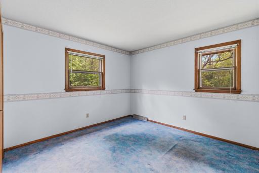 The first of two bedrooms on the main floor, these windows overlook the north and west yards of the property.