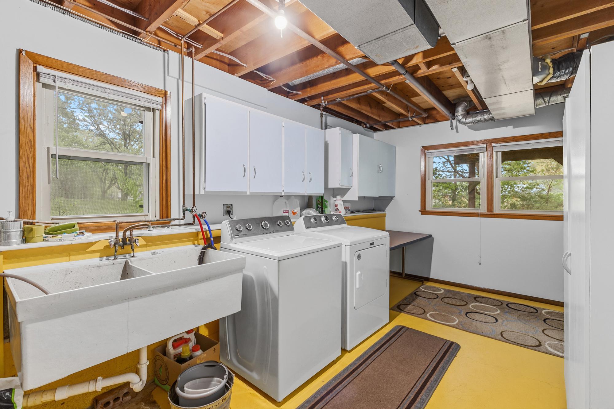 The laundry room has lots of natural light that streams in from newer windows. The washer and dryer are newer, too. This room also has loads of storage space and still room for a folding table.