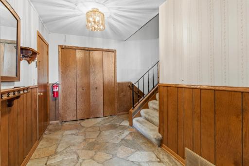 Inside the home, you're welcomed into a flagstone paved, oversized entryway. The door to the left in this photo opens to the attached garage.