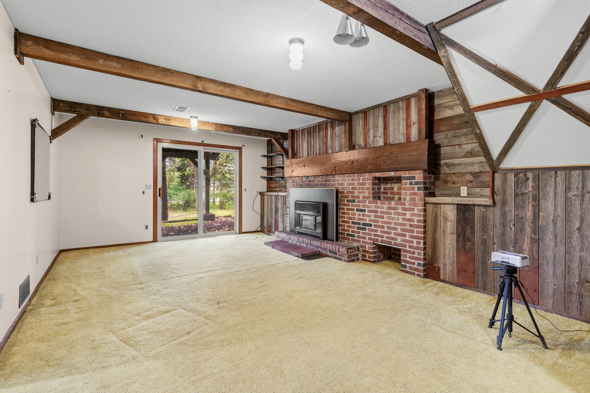 Heading downstairs to the family room, you're treated to a second wood-burning fireplace and another set of newer sliding glass doors that step out to the area under the deck.