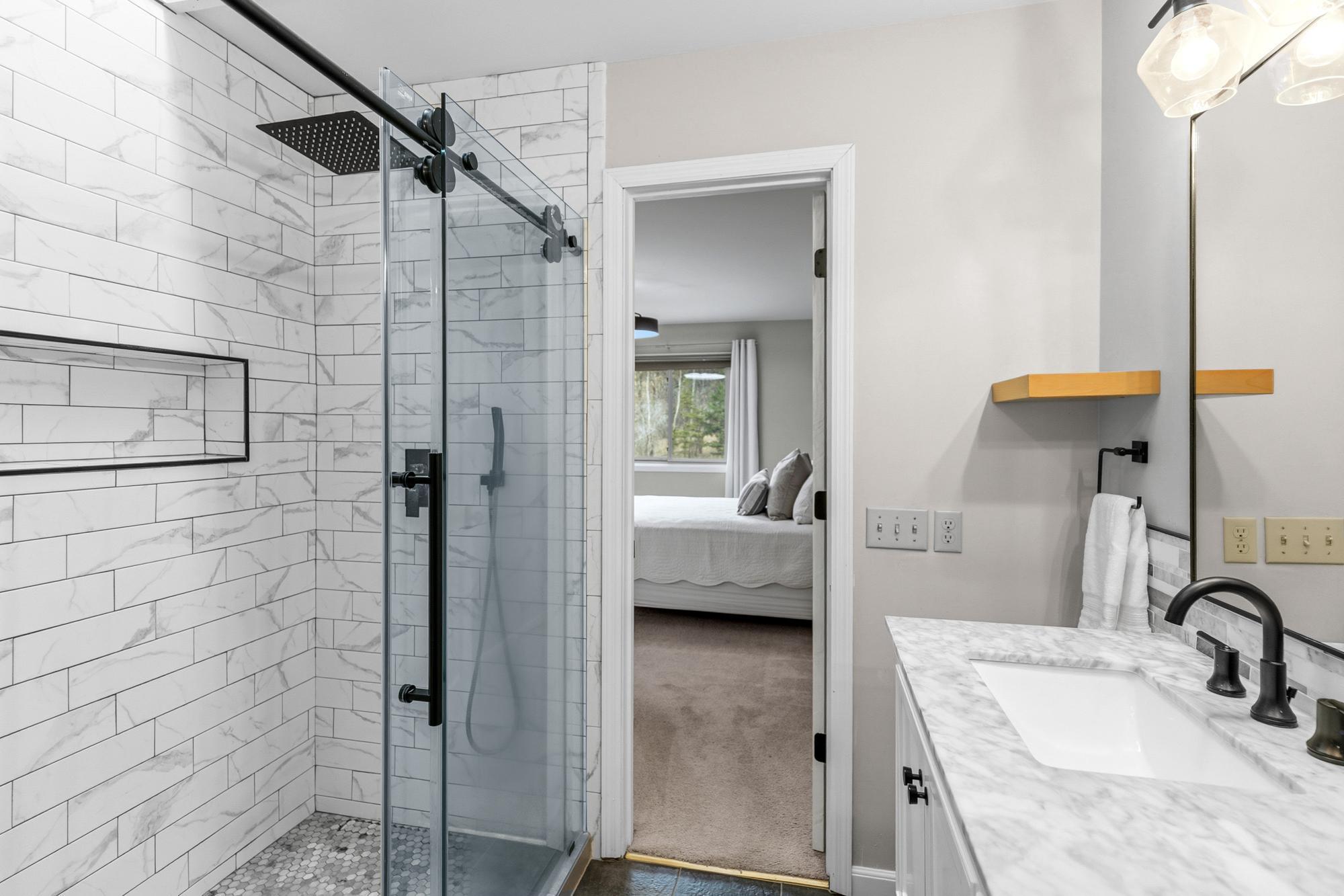Granite counters, modern subway tiled walls, penny tiled shower floor, and sleek black fixtures and finishes will make the daily grind of cleaning up one to be enjoyed.