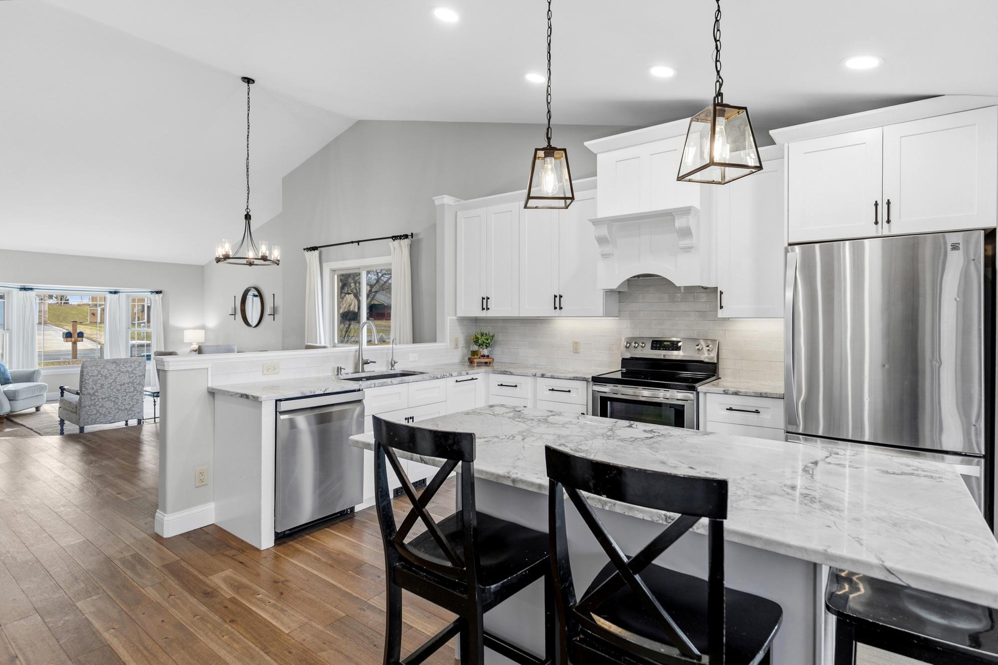 open site lines, a breakfast bar/island, tasteful decor lighting...