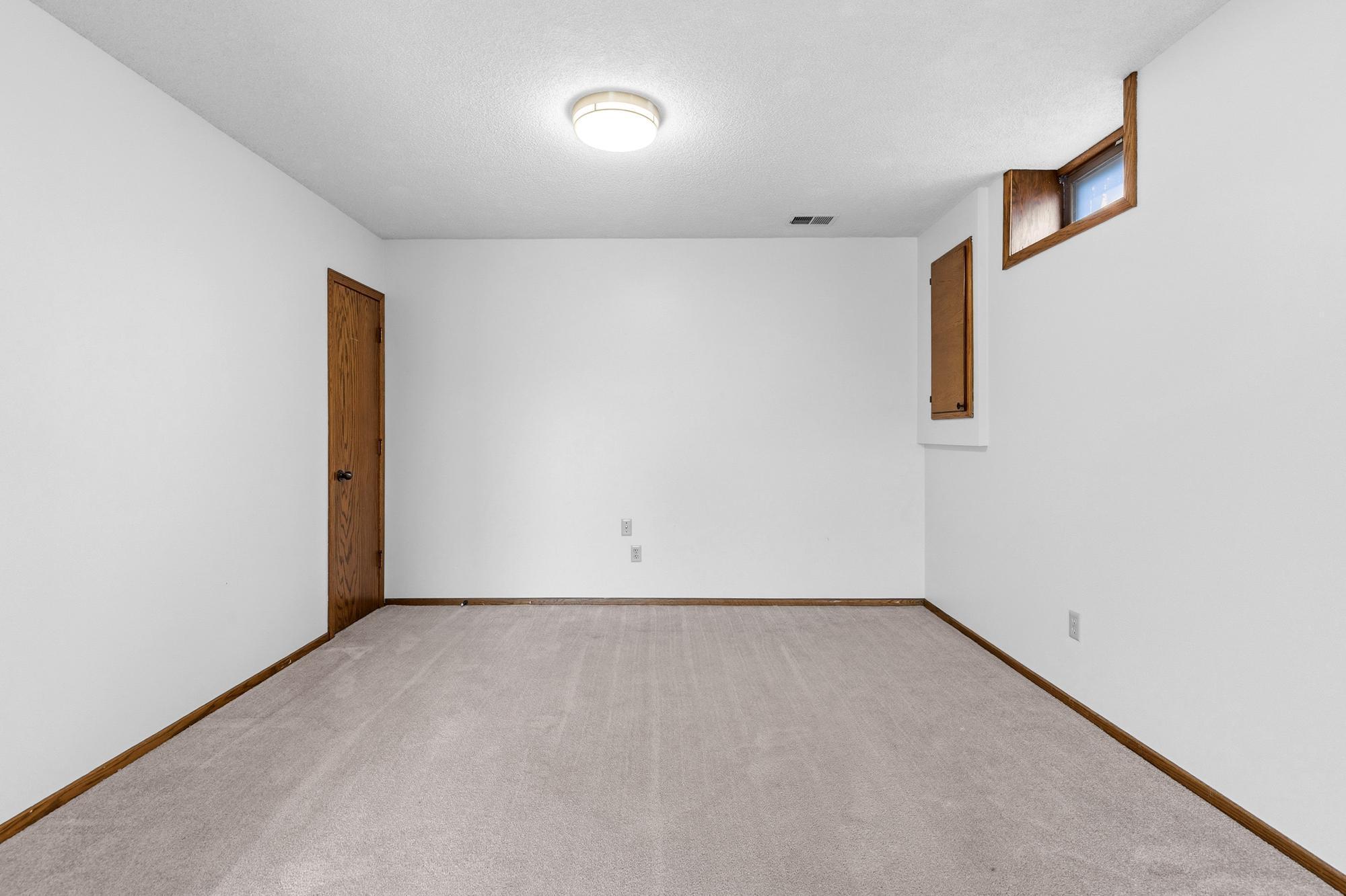Additional space at the back of this room would work well for a game table or a crafting area. The door to the left opens to a sizable under-stairs storage area. The small door to the right houses the electrical panel.