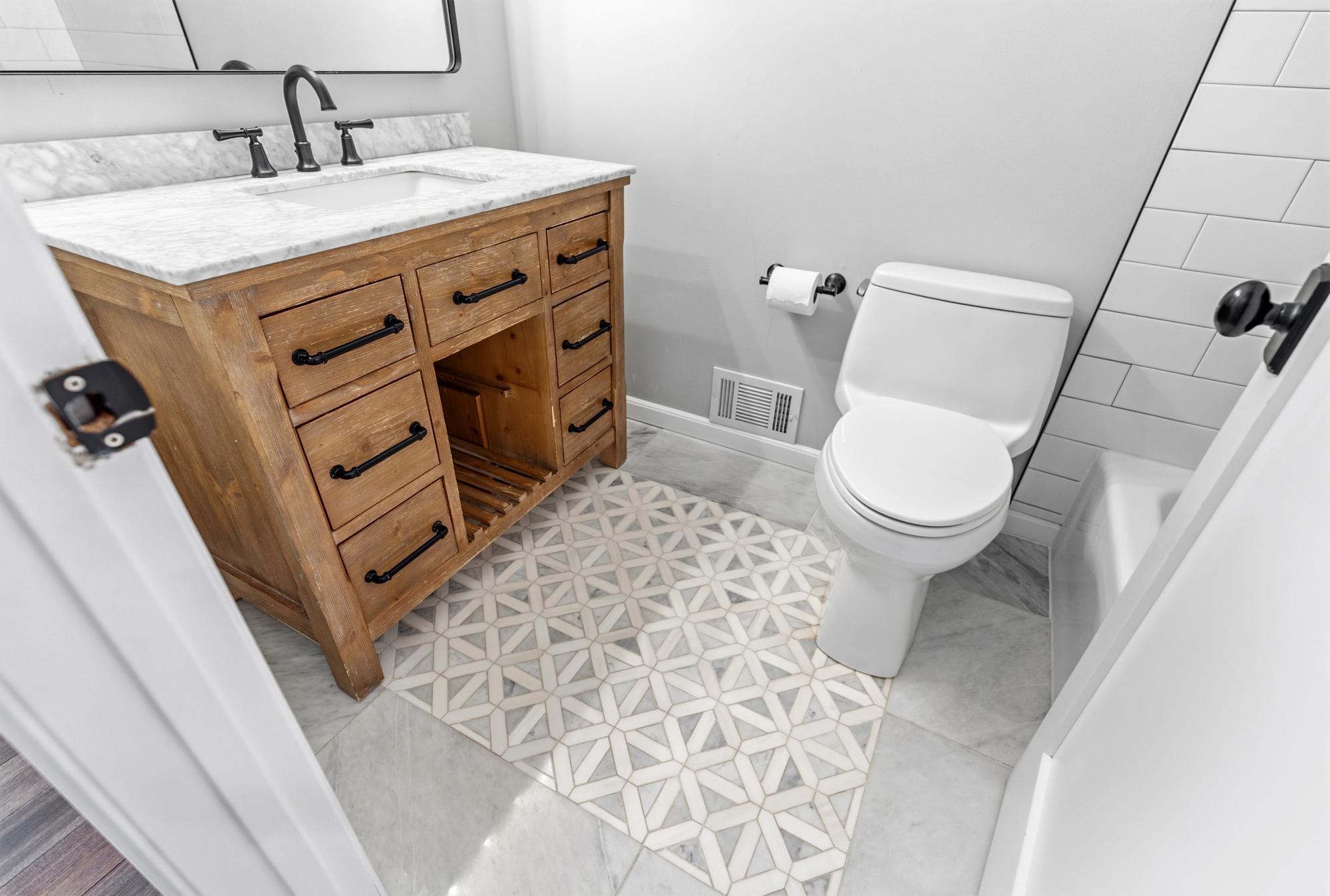 Along with the classic subway tile shower surround, this bathroom also boasts a gorgeous tile inlay on the floor.