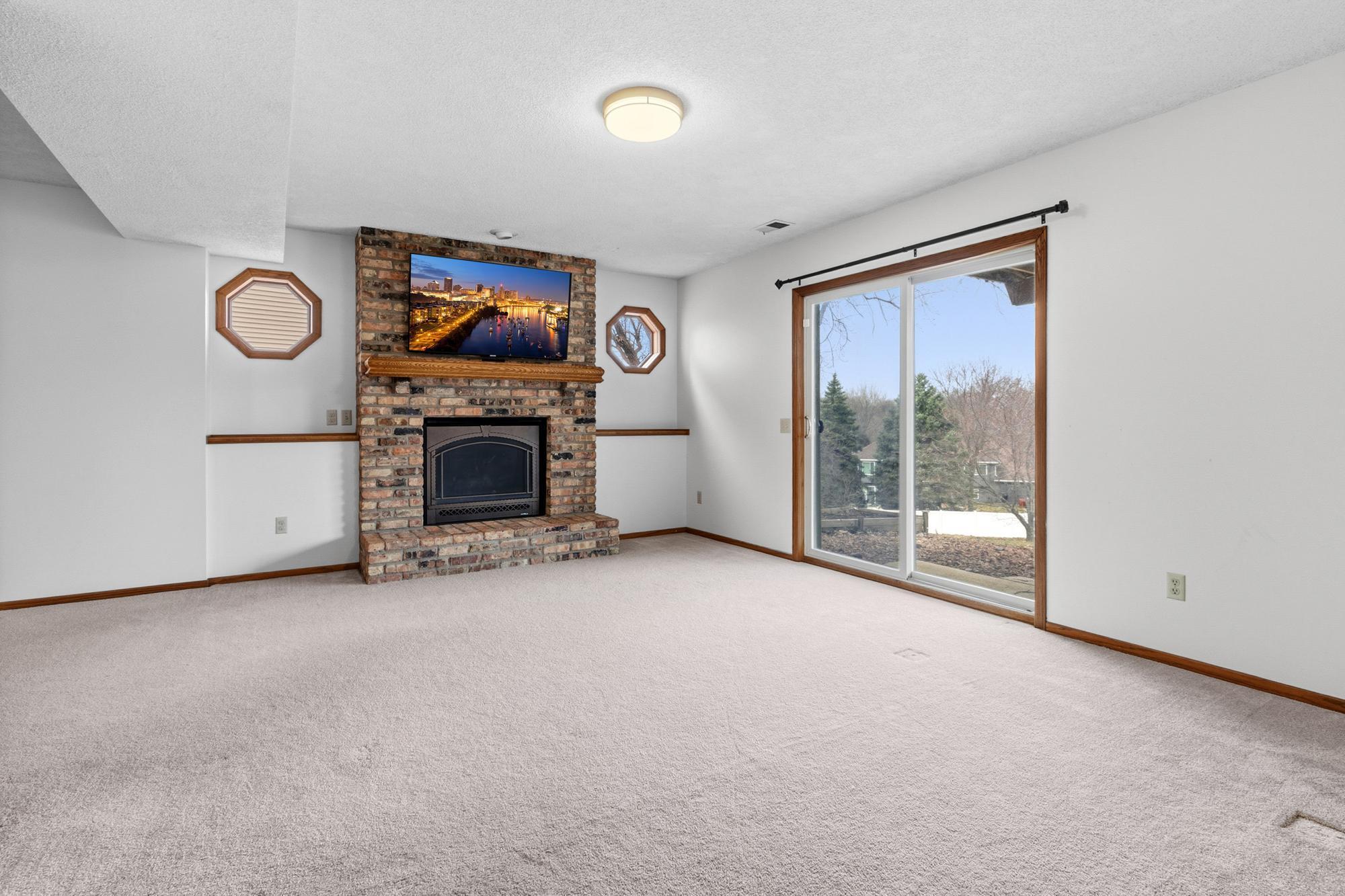 Heading down to the walk-out lower level, you're first greeted with a gas fireplace and sliding doors out to the back yard.