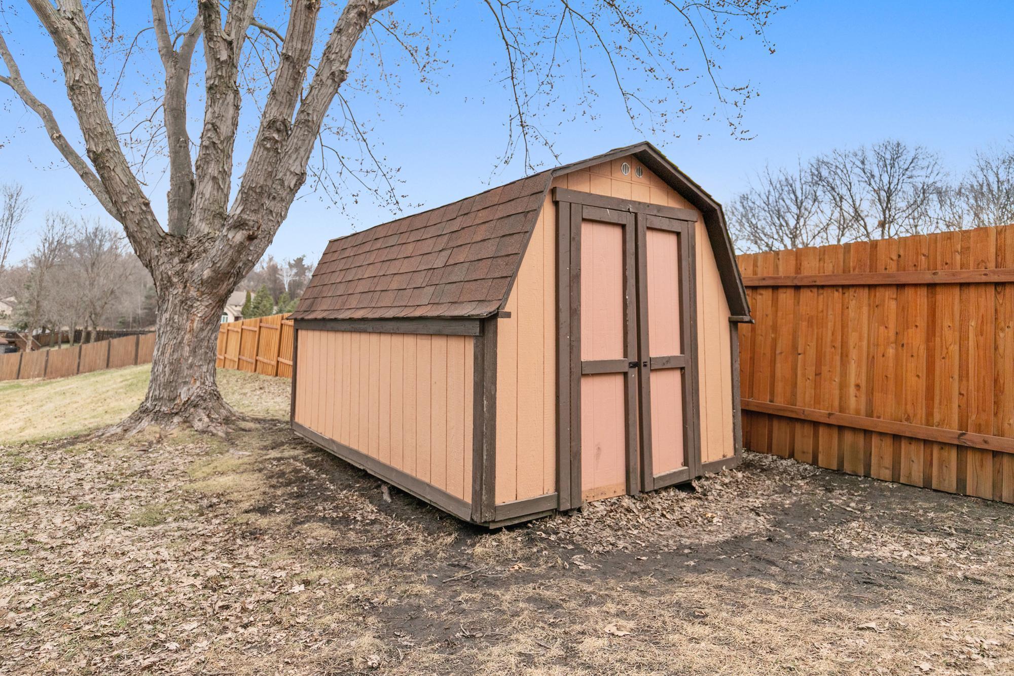 A storage shed keeps garage space available for cars.