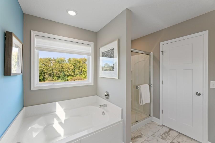 (Photo of decorated model, colors and features will vary) Glass shower door is included - no shower curtain necessary! Both the soaking tub and shower have LED lighting.