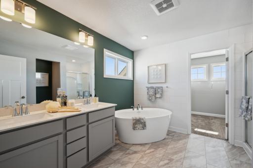 (Photo of model home, features will vary) Dual sinks and a separate soaking tub contribute to the spa-like atmosphere of the en-suite bathroom.