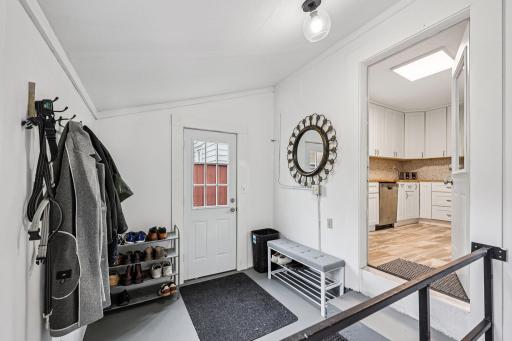 Mudroom with door to the backyard and stairs to the basement