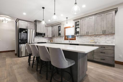 Alder cabinetry with soft-close drawers, quartz countertops, and a stunning 9-foot center island with breakfast bar seating.