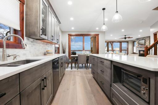 The impressive main level features 9-foot ceilings, engineered wood flooring, and dramatic floor-to-ceiling windows that flood the home with natural light.