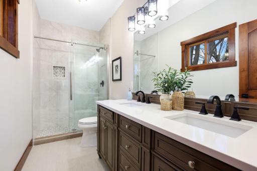 A beautifully appointed ensuite features a tiled walk-in shower and double vanity.