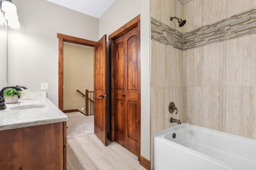 A spa-inspired full bath with tile flooring, a double vanity, and generous storage completes this level.