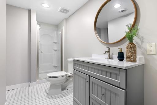 Convenient lower-level bathroom with walk-in shower and vanity storage.
