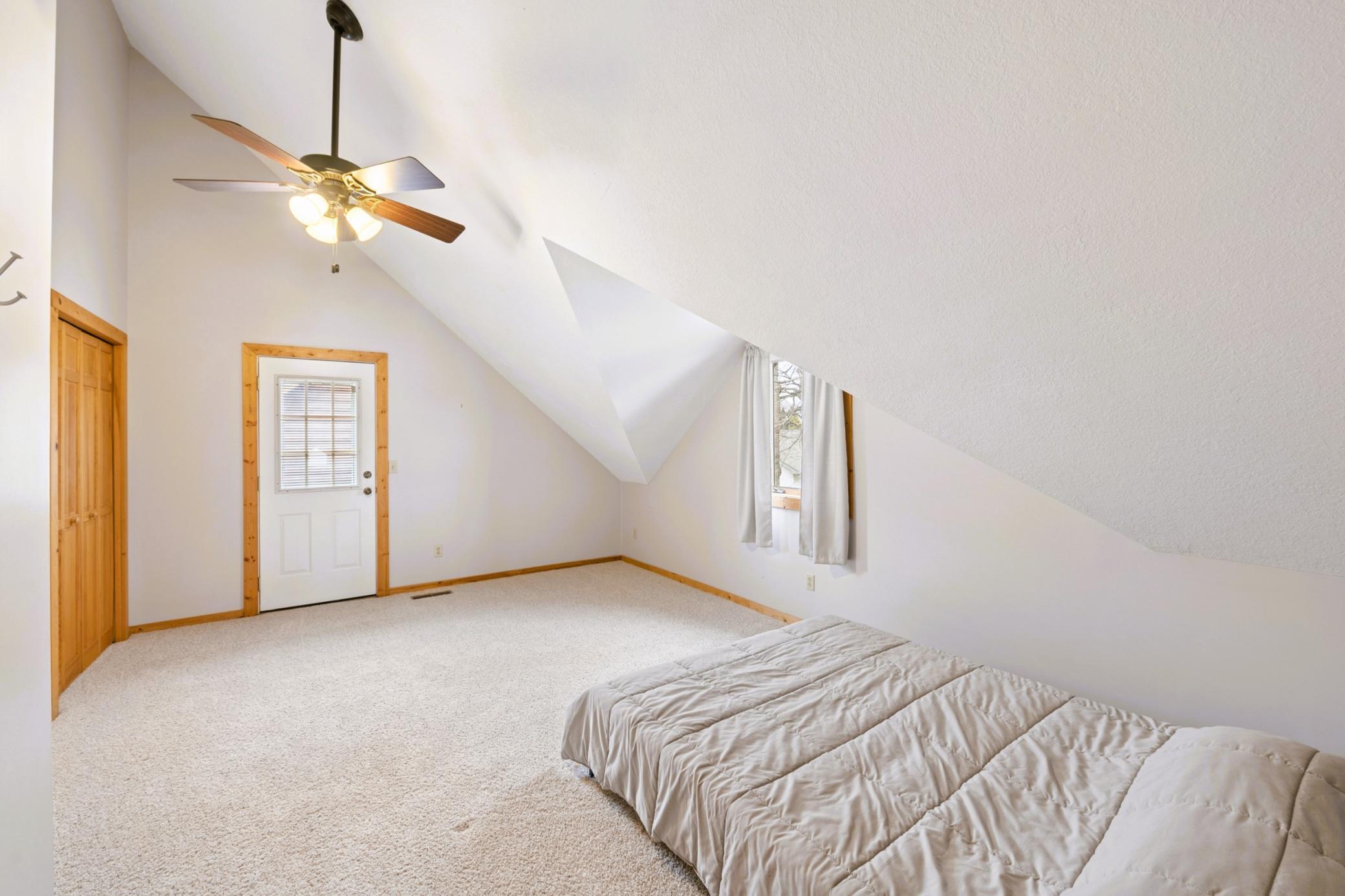 Large vaulted bedroom 3 on the upper level with walk-out balcony.
