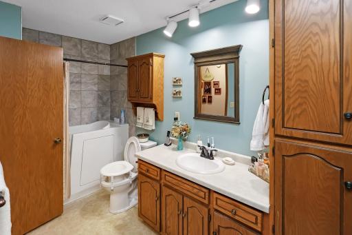 Updated walk thru full bathroom with a walk-in tub/shower.