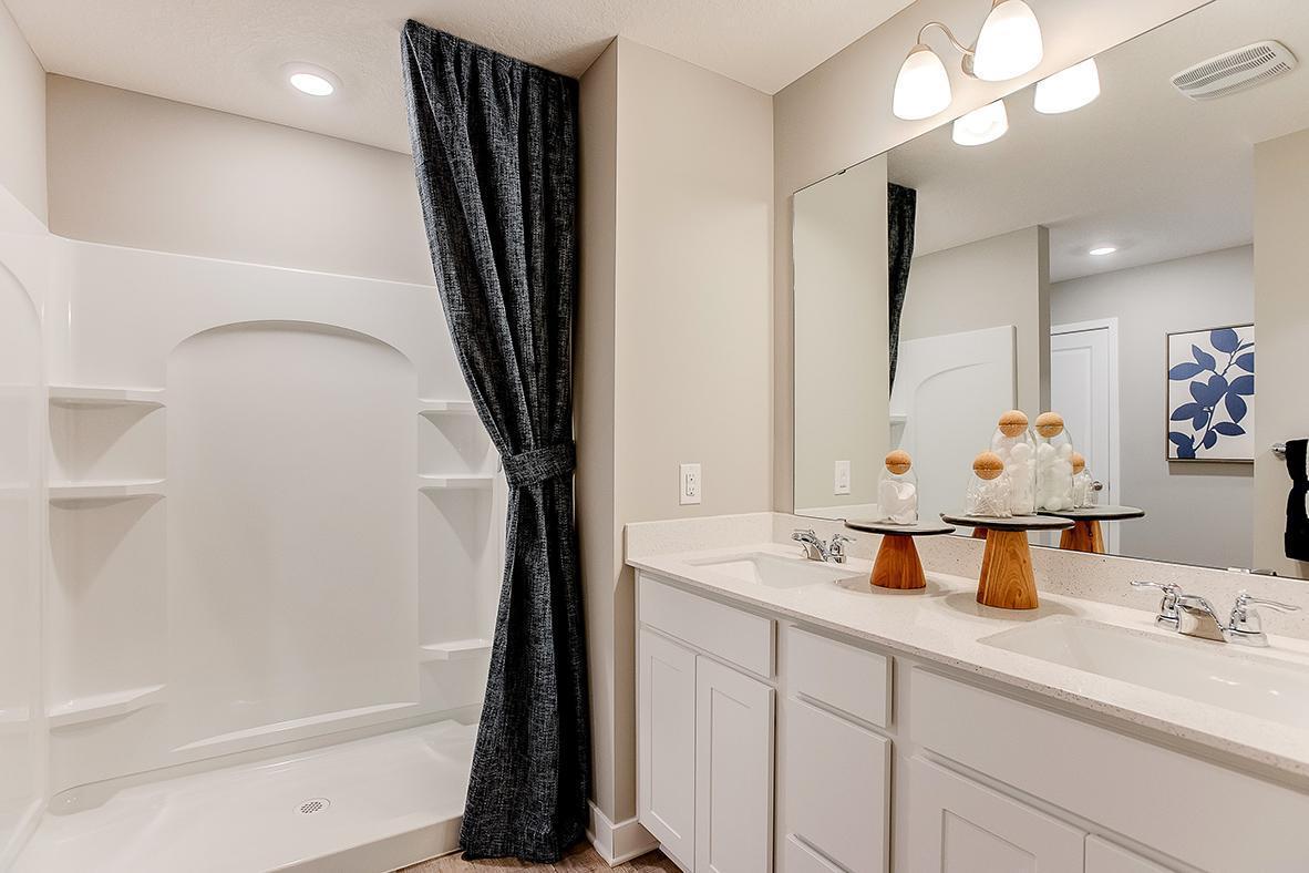 A peak into the primary bath, which features a Quartz coated double-vanity - making getting ready on those hectic mornings that much easier - and oversized stand-in shower! (Photo of model, colors are similar)