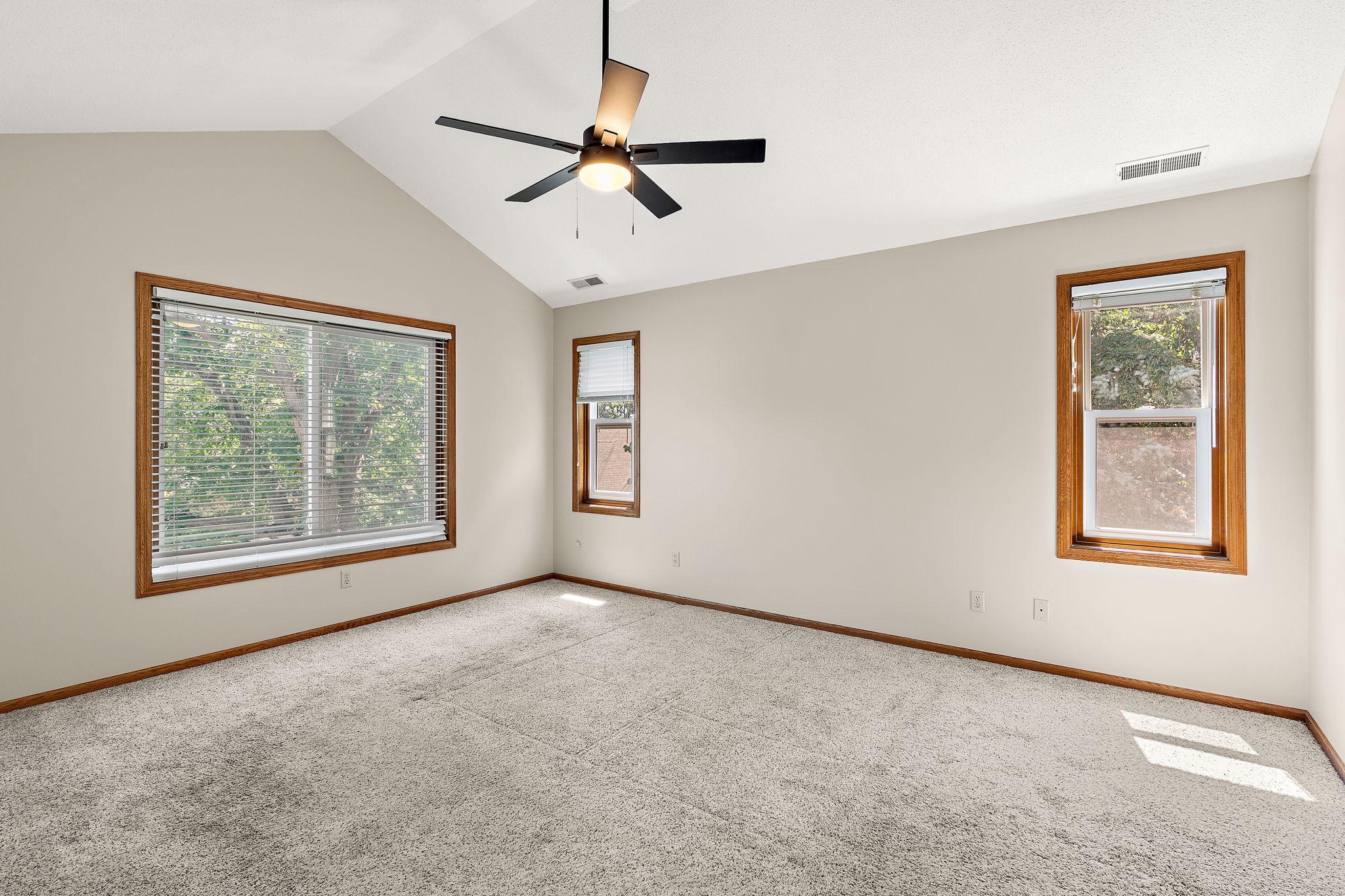 Primary bedroom with vaulted ceiling and lots of natural light. Freshly painted.