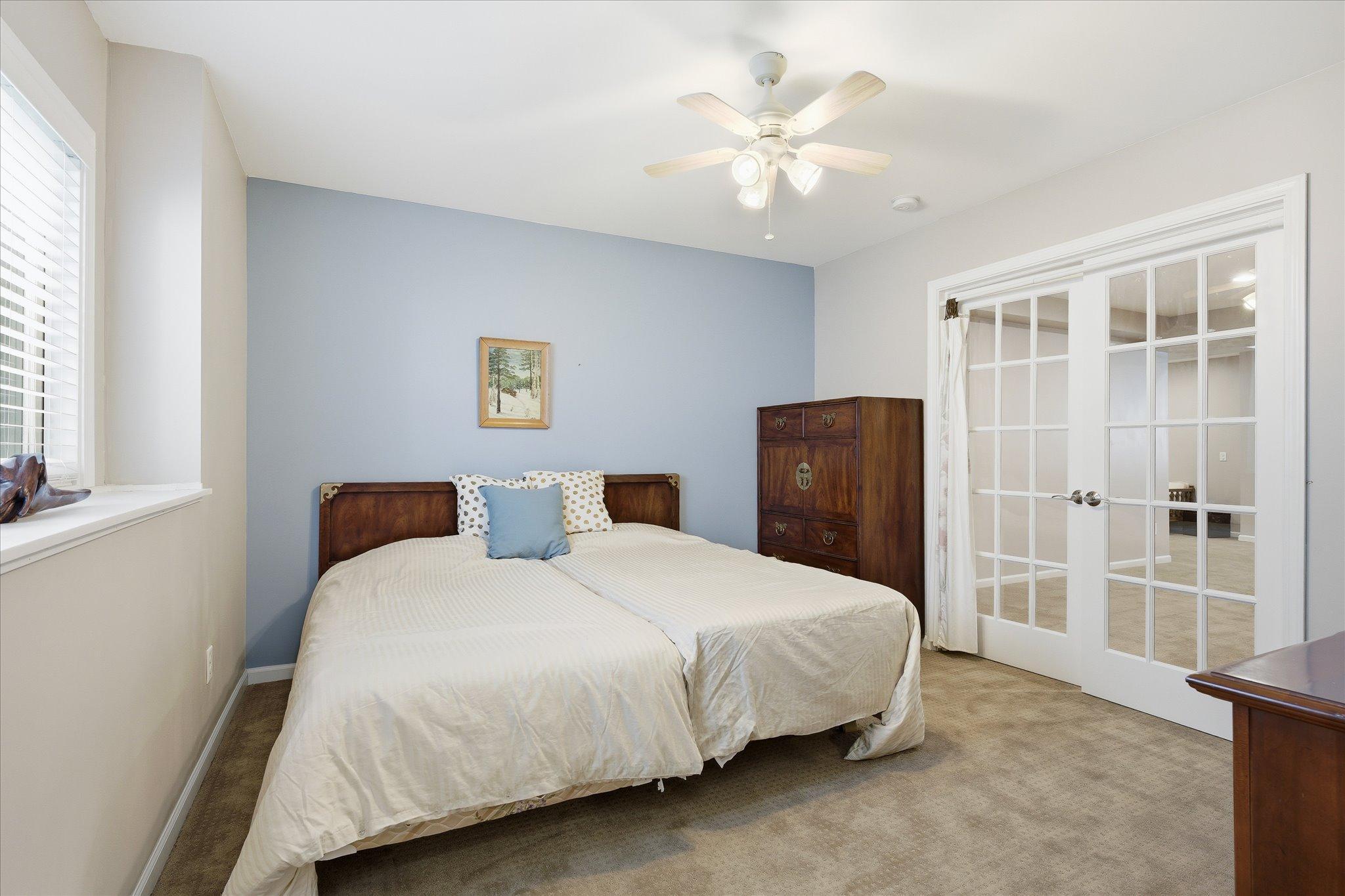 French doors add charm and character to this spacious lower-level bedroom while enhancing the room’s flexible design.