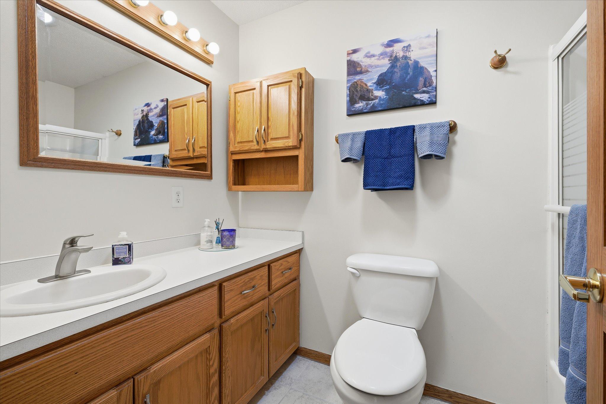 Extensive cabinet storage, built-in shelving, and generous counter space make this full bathroom on the main floor both functional and organized for daily routines.