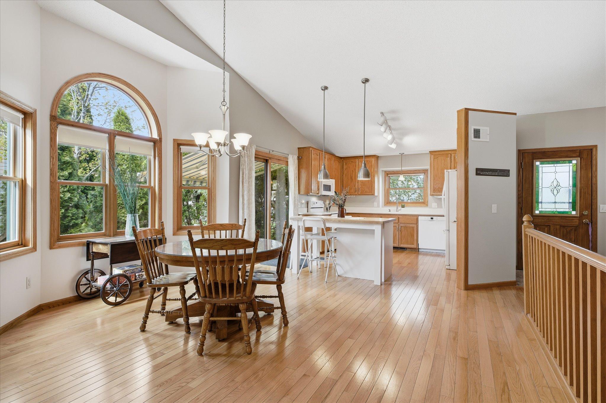Natural light pours through the home, highlighting the open floor plan connecting the living room, dining area, and sunroom.