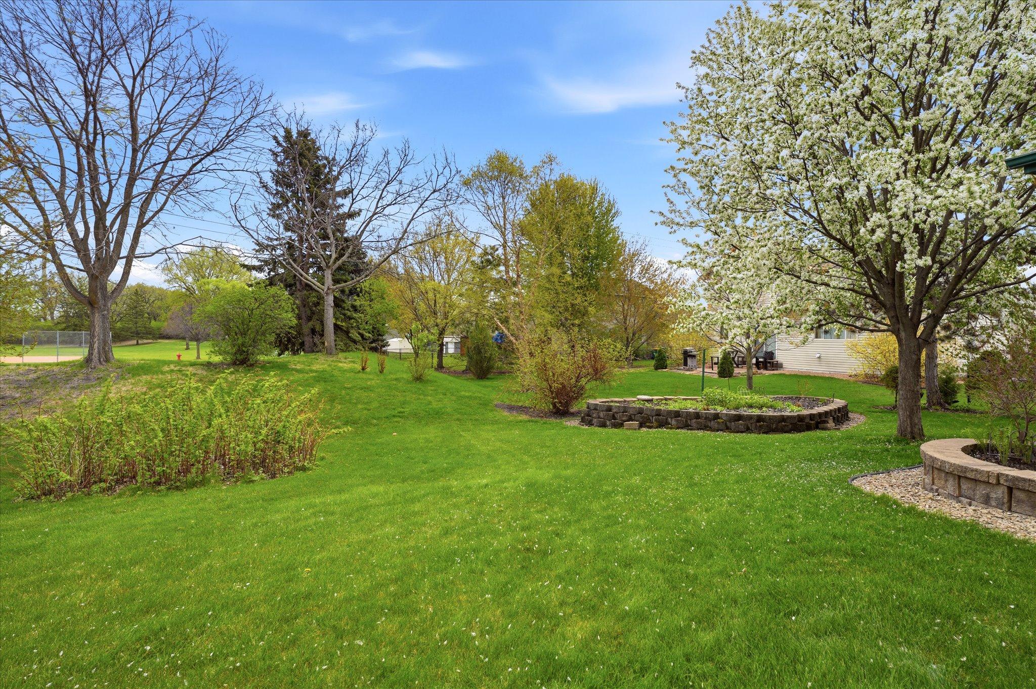 Surrounded by mature landscaping, the backyard offers a quiet and private outdoor setting perfect for relaxing or entertaining.