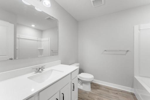 The main bathroom on the upper level features an oversized vanity and ample storage for all your bathroom essentials. Colors and finishes may vary.