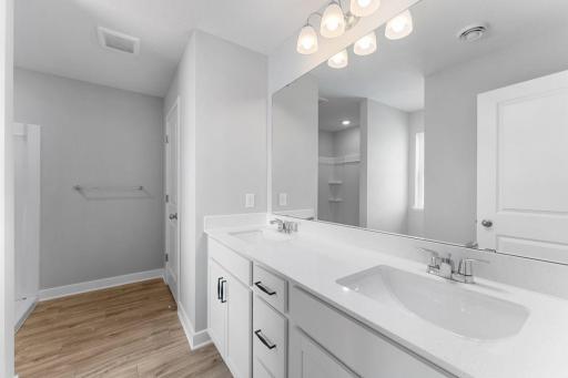 Enjoy dual sinks on an oversized vanity in the private primary bathroom. Colors and finishes may vary.