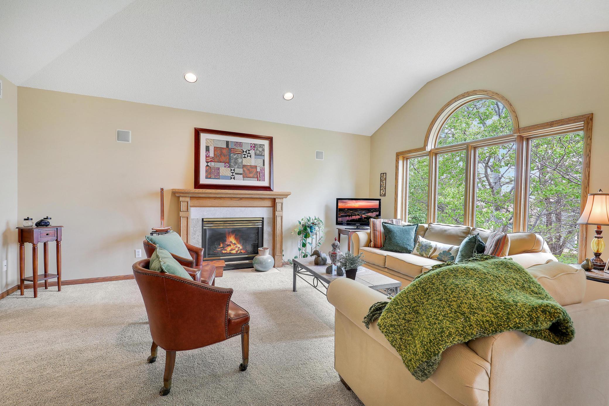 Living room boasts a beautiful gas burning fireplace with vaulted ceilings and huge windows overlooking the backyard!