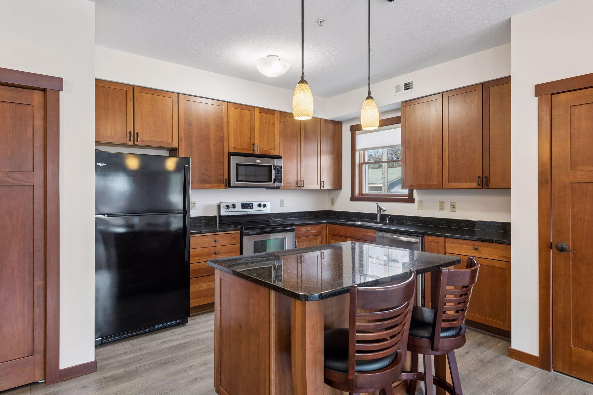 Efficient and lovely center island with seating, storage, and pendant lighting.